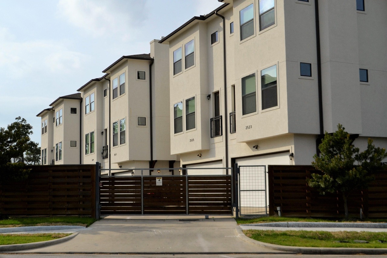 I need an image of the front of a gated community, just show a main gate entrance. Do NOT use any text in this image. Make it realistic. Do not make the gate too large. 